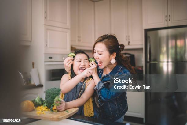 An Asian Chinese Housewife Having Bonding Time With Her Daughter In Kitchen Preparing Food Stock Photo - Download Image Now