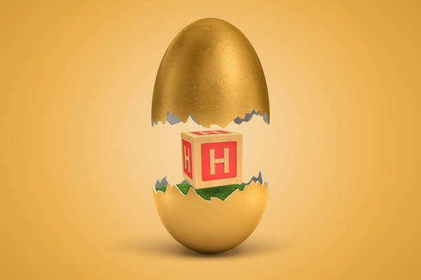istock 3d rendering of gold egg cracked in two, upper half levitating in air, lower on ground, with small wooden ABC block with letter H on sides between two halves. 1180194375