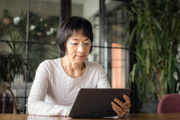 istock Senior Chinese woman using a digital tablet 1180196328