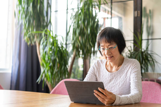 istock Senior Chinese woman using a digital tablet 1180196412