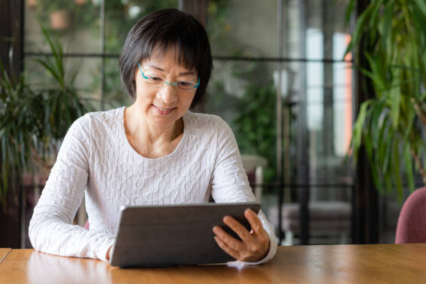 istock Senior Chinese woman using a digital tablet 1180196462