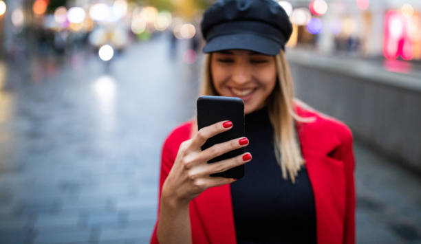 istock Young woman walking on pedestrian zone and using phone 1180196516