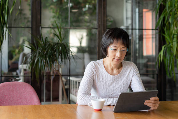 istock Senior Chinese woman using a digital tablet 1180197065