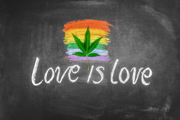 The word love ia love written on a chalk board. LGBTQ. LGBT rainbow flag and hemp stock photo