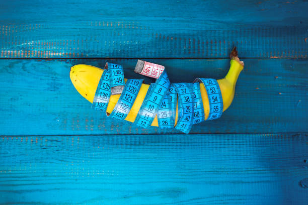 measure tape wrapped around banana stock photo