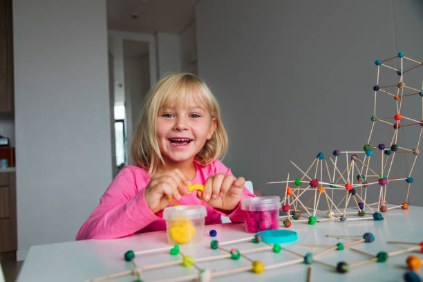 istock cute girl making geometric shapes from clay, engineering and STEM 1180197357
