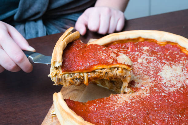 fotografii de stoc, fotografii și imagini scutite de redevențe cu vedere de top a pizza chicago. femeie mâinile de tăiere chicago stil farfurie profundă pizza brânză italiană cu sos de roșii și carne de vită întâlni în interiorul - tureen