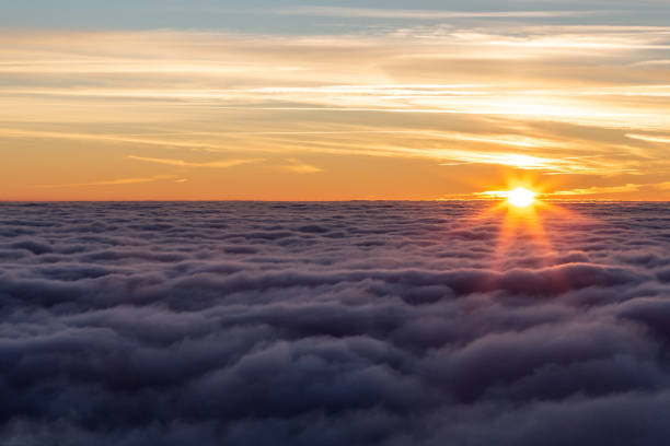 istock Beautiful sunset over a valley filled by fog 1180201245
