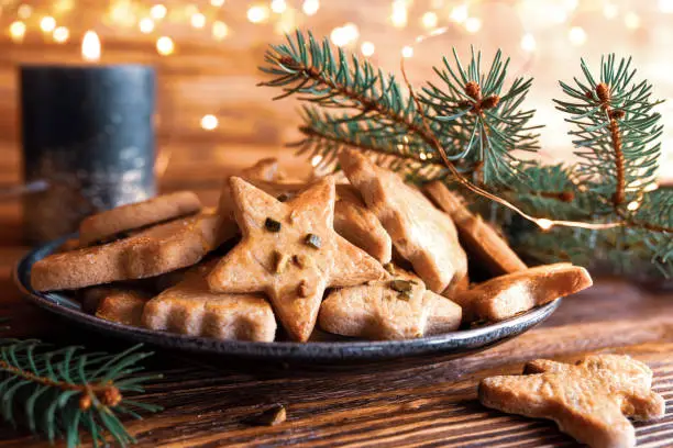 Tasty homemade christmas cookies with festive golden lights on rustic wood