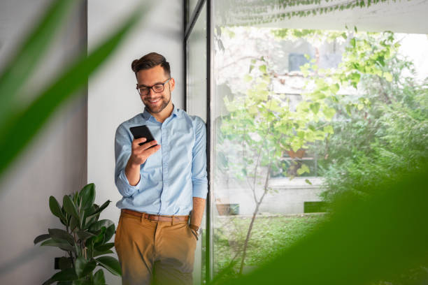 istock Young man typing on mobile phone 1180205347