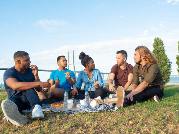 istock Diverse friends eating pizza outdoors 1180205883