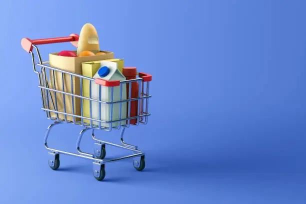 Photo of Shopping cart full of food on blue background
