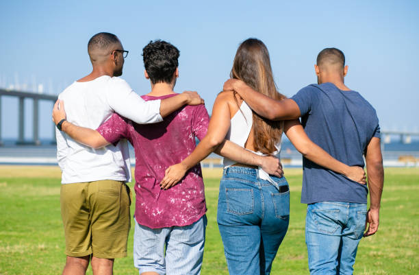 istock Team of friends embracing outside 1180210122