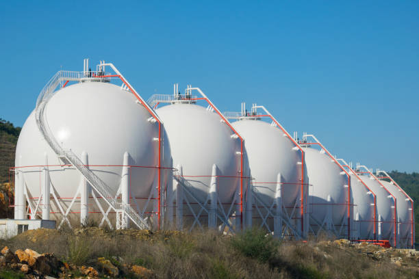Liquefied gas storage tanks Liquefied natural or petroleum gas white storage tanks on the roadside. liquefied natural gas stock pictures, royalty-free photos & images