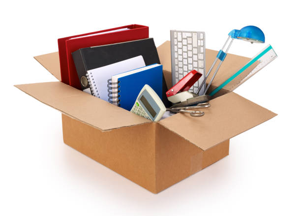 istock Cardboard moving box filled with office supplies on white background. 1180211117