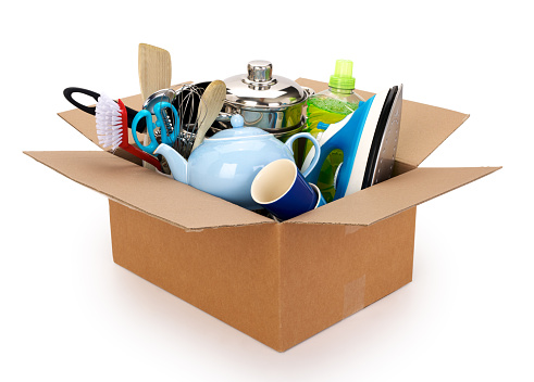 Moving house cardboard box filled with household and kitchen utilities, isolated on white background. Contains clipping path.