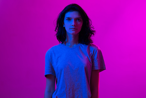 Young woman in pink blue neon lights. Creative colorful portrait.