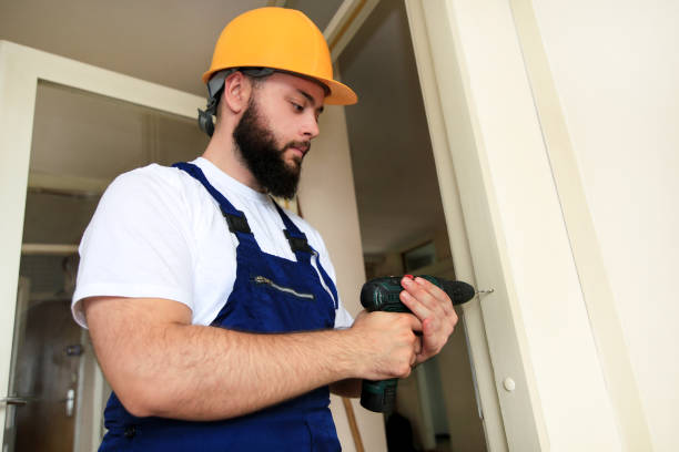 istock Construction worker and handyman works on renovation of apartment. Builder with electric drill drills nail hole into wooden wall door at construction site. Home renovation concept. Construction tool. 1180213044
