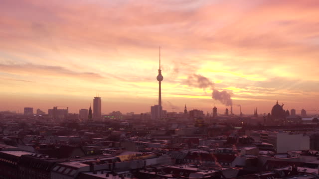 AERIAL: Beautiful Fall/Winter Morning Sunrise over Berlin TV Tower Alex / Alexanderplatz with with smoke on rooftops with blood Red orange sky light (Winter, Big City) 4K