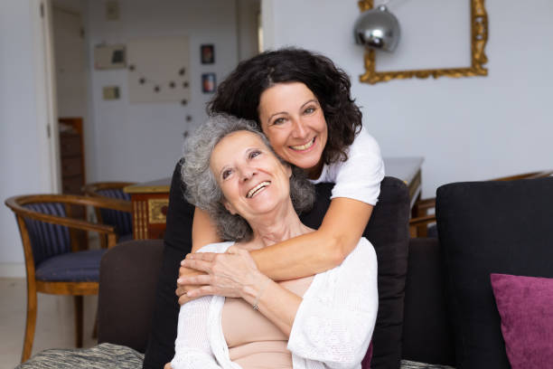 istock Happy middle aged woman hugging senior lady 1180214474