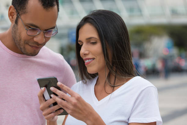 istock Front view of good friends looking at smartphone 1180216723