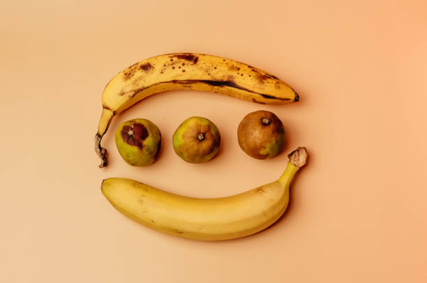 istock Ugly fruit modification of bananas from ripe to more spoiled brown with spots and decayed limes isolated. The concept of fruit is not salable for supermarkets. 1180216827