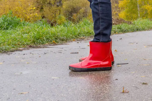 Feet in red rubber boots on an asphalt track