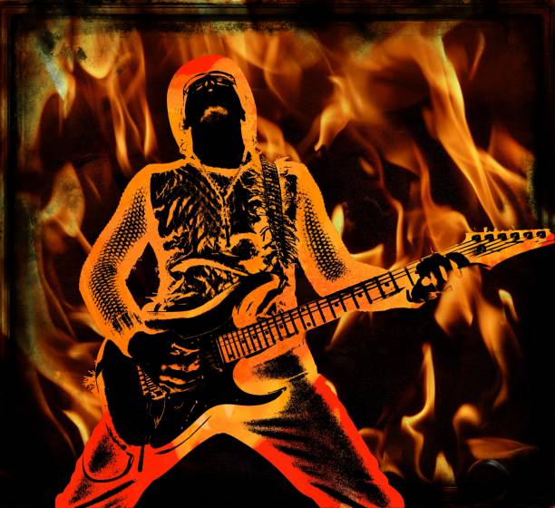 Cool rock guitarist in a hat playing the electric guitar on a fire backdrop. Musician with an instrument performing on a stage. stock photo