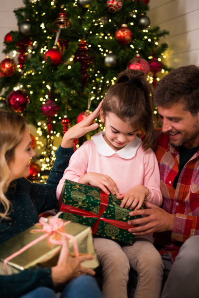 istock Girl getting a gift box for Christmas from her parents 1180222003