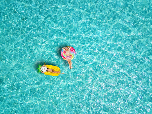 pareja disfruta del mar tropical y el sol en coloridos inflables - honeymoon beach swimming pool couple fotografías e imágenes de stock