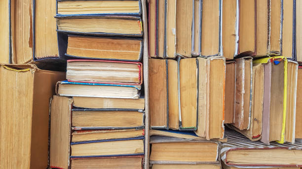 istock Many sorted old books are stacked as a background front view. Stack of used old books in the school library. Old and used hardback books or textbooks are visible from above 1180224404