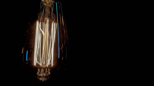 istock Lighting decor. Vintage hanging edison light bulb on a dark background. Old dusty light bulbs glowing in the dark. A lamp inside a decorative glass lamp. Light begins to appear and glow in the center 1180224637