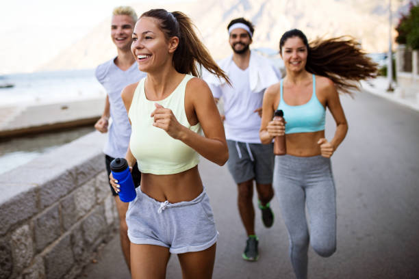 istock Group of young people friends running outdoors at seaside 1180224848