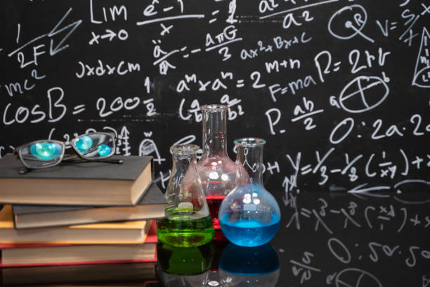 glasses on old books and experiment bottle on a black table with a blackboard on the background. - old laboratory alchemy alchemist imagens e fotografias de stock