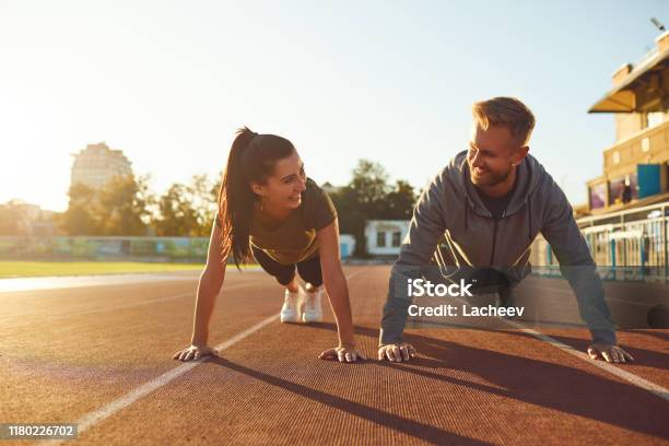 Junges Paar Beim Pushup Im Stadion Stockfoto und mehr Bilder von Fitnesstraining - Fitnesstraining, Im Freien, Sporttraining