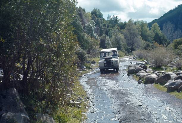 Jim corbett national park, Ramnagar, Uttarakhand, India - February 7, 2022 - wildlife safari or scenic game drive gypsy or jeep half in water of ramganga river crossing dhikala forest or tiger reserve