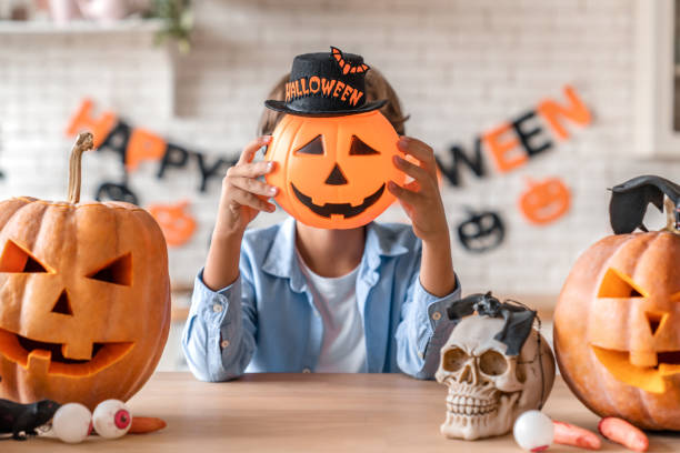 istock Little boy having fun with pumpkin on Halloween at home kitchen 1180227705