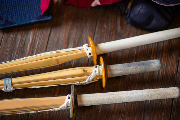 Bamboo swords close-up. Kendo gloves, helmet and bamboo sword on a wooden surface. Bamboo swords close-up. Kendo gloves, helmet and bamboo sword on a wooden surface. Kendo armor. kendo stock pictures, royalty-free photos & images
