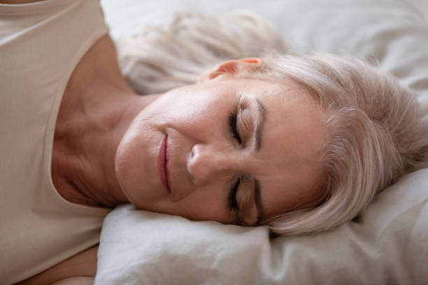 istock Relaxed beautiful mature woman sleeping in comfortable bed close up 1180231120