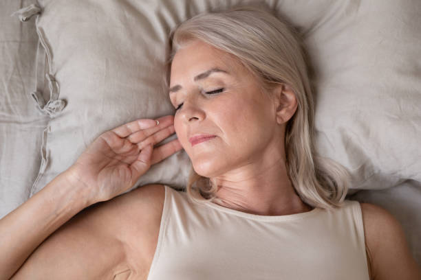 istock Peaceful beautiful mature woman sleeping in bed close up 1180231124