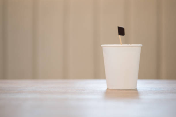 istock White disposable paper cup on wood table 1180232249