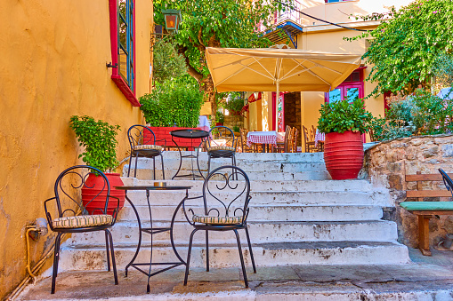 Charming street cafe on the stairs in Plaka district in Athens, Greece