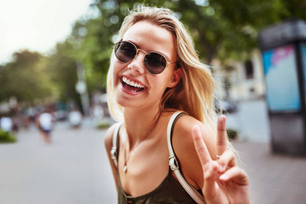 pace fuori bel mondo - sunglasses women smiling portrait foto e immagini stock