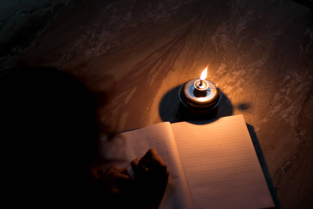 istock A student writing on notebook in a kerosene oil lamp 1180234179