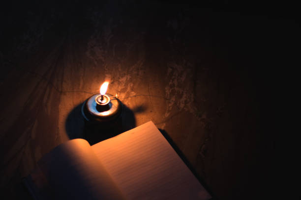 istock A student writing on notebook in a kerosene oil lamp 1180234536