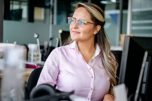 istock Cheerful woman in office smiling and looking away 1180235428