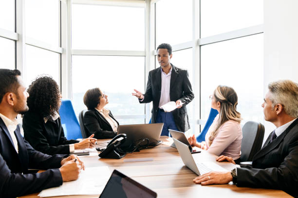 istock Businessman explaining to colleagues in board meeting 1180235435