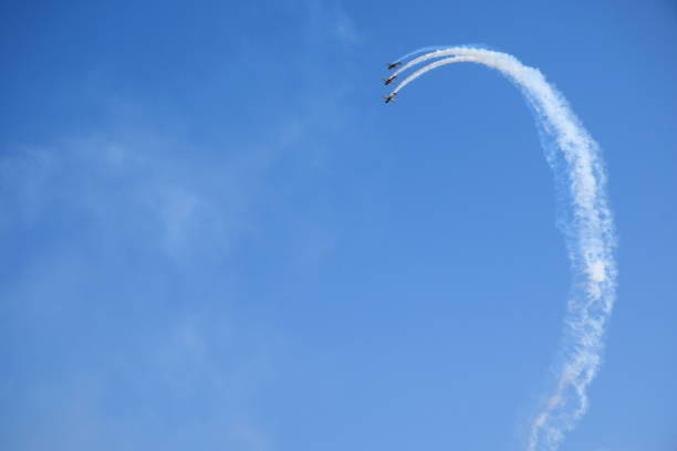 istock Three white and red passenger stunt planes flying dynamically across the sky and doing a barrel roll all together seen during a cloudy yet warm summer day in Poland 1180239561