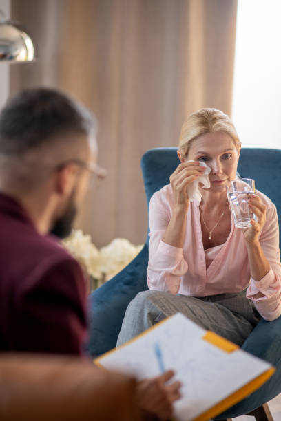 istock Woman crying and drinking water while listening to psychoanalyst 1180241134