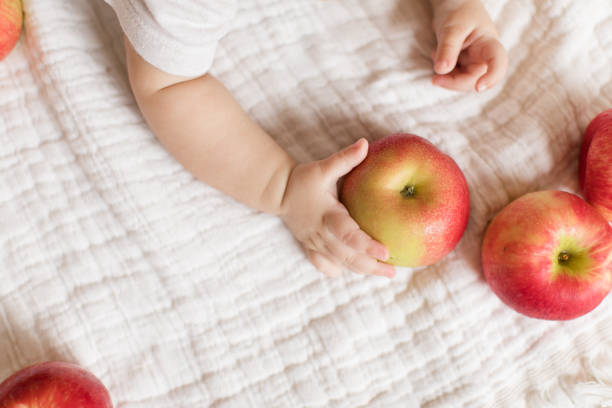 istock Baby Girl Holding Apples 1180241879